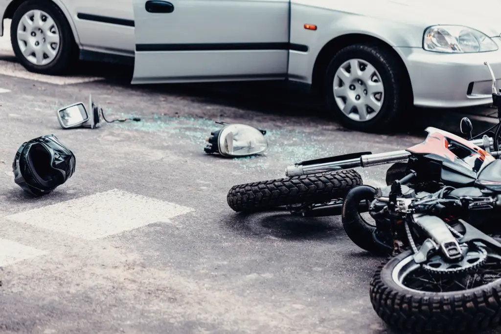 Helmet, mirror and a car lamp between car and motorcycle after terrible road accident
