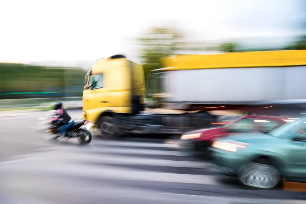 Dangerous city traffic situation with a motorcyclist and a truck